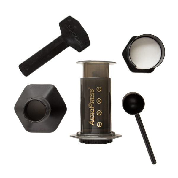 Top-down view of the AeroPress coffee maker and included accessories: plunger, chamber, scoop, stirrer, and filter holder.