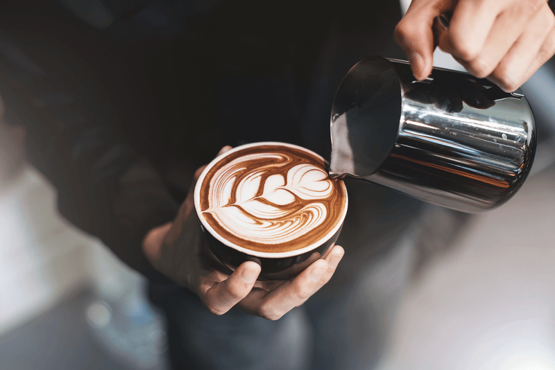 Latte art being poured into the coffee