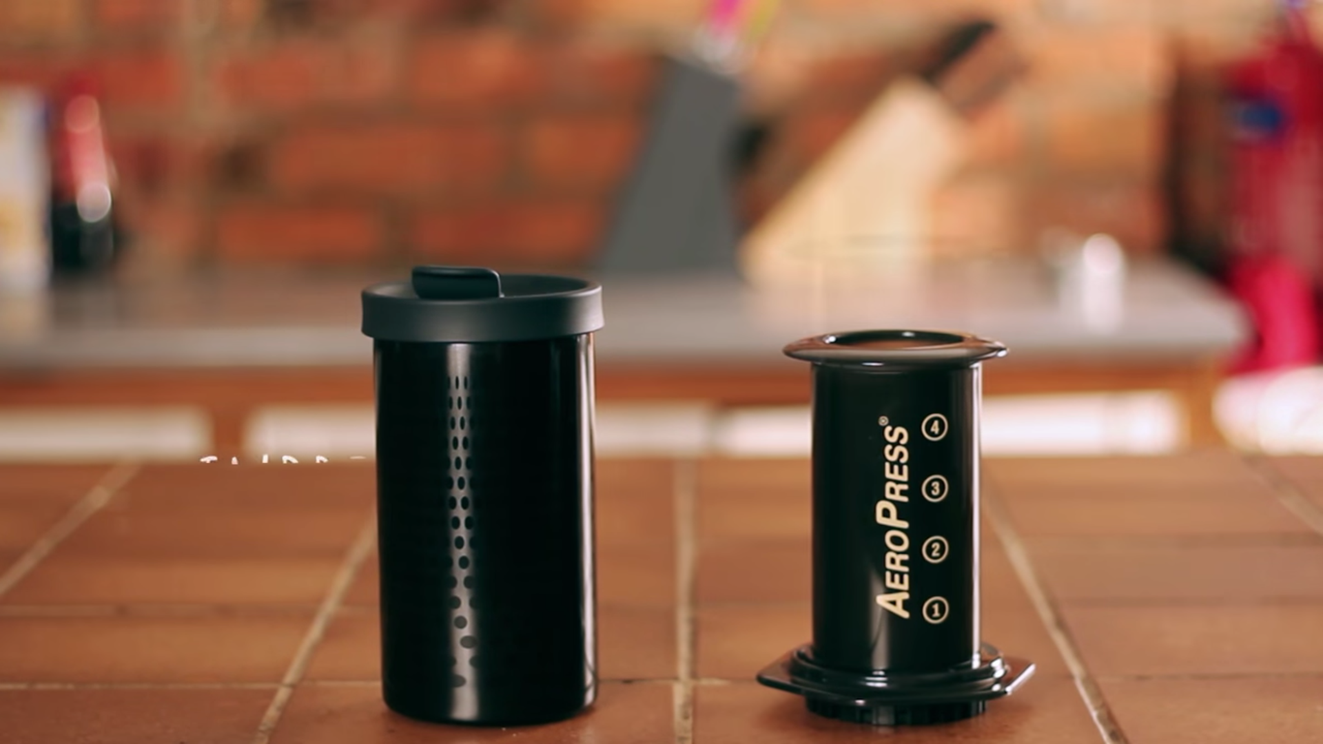 Side-by-side comparison of the AeroPress coffee maker and Impress coffee brewer on a kitchen counter.